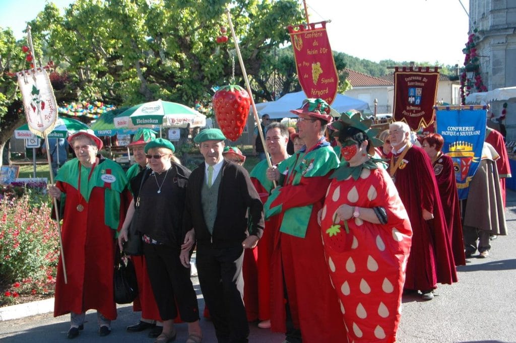 Fête de la fraise à Vergt avec le défilé des gens déguisés de la confrérie de la fraise